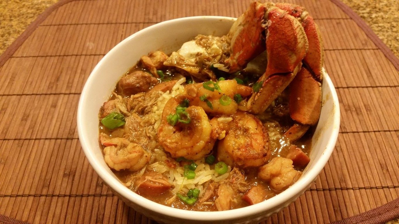 A bowl of shrimp and lobster stew on a bamboo mat