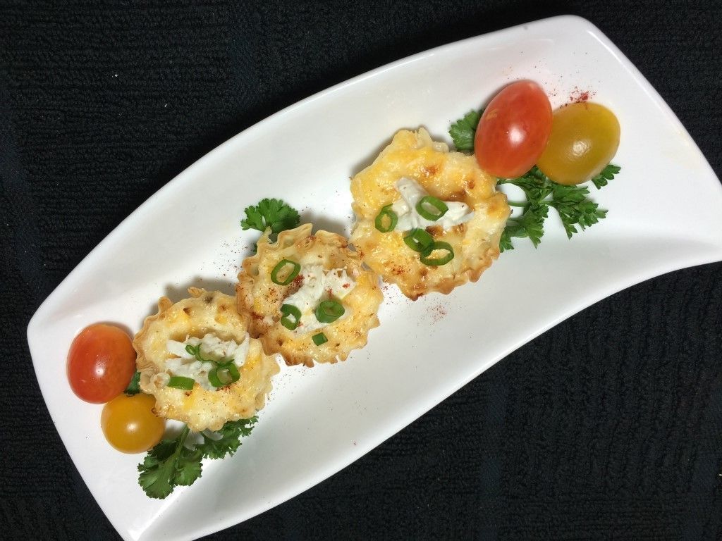 A white plate topped with fried food and tomatoes