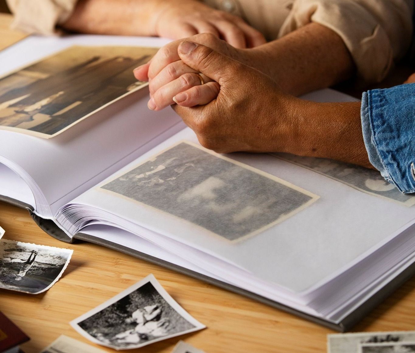 a person holding another person 's hand while looking at a photo album after Bereavement of a loved one 