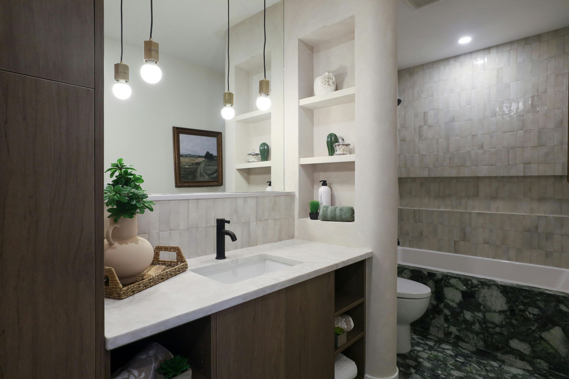 Modern bathroom vanity with hanging lights, white shelves, and marble tile accents