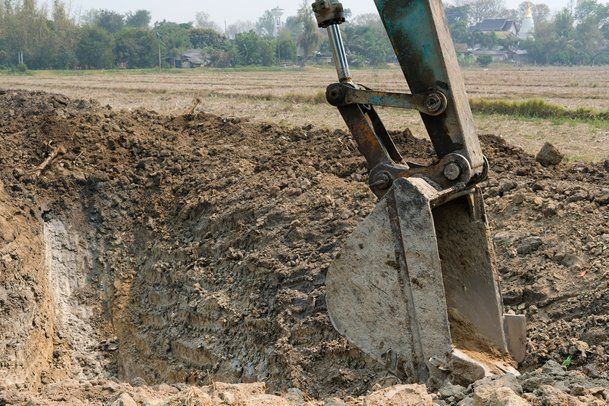 Picture of an excavator digging out a hole for a pond.