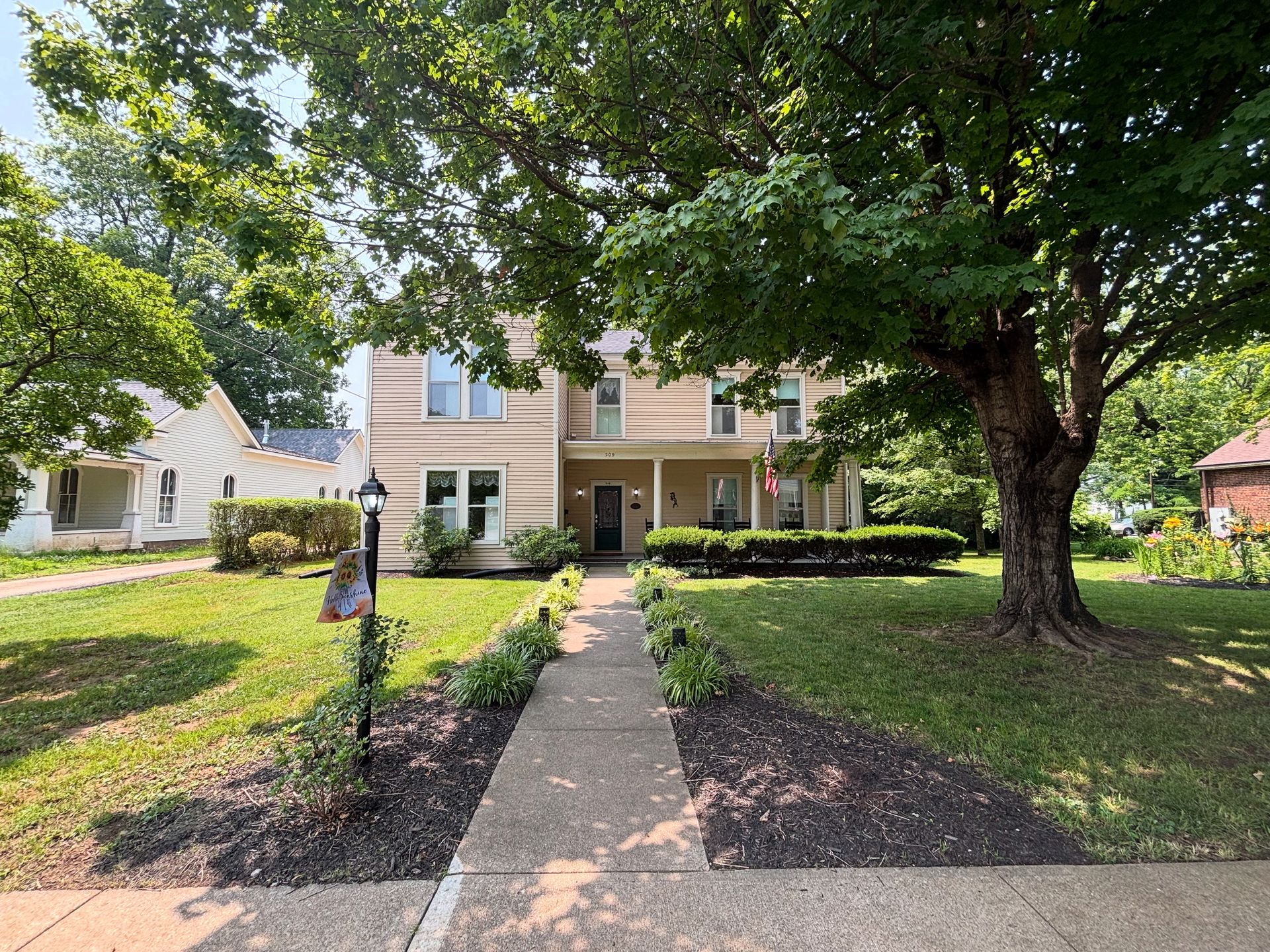 A large house with a porch and an american flag on it