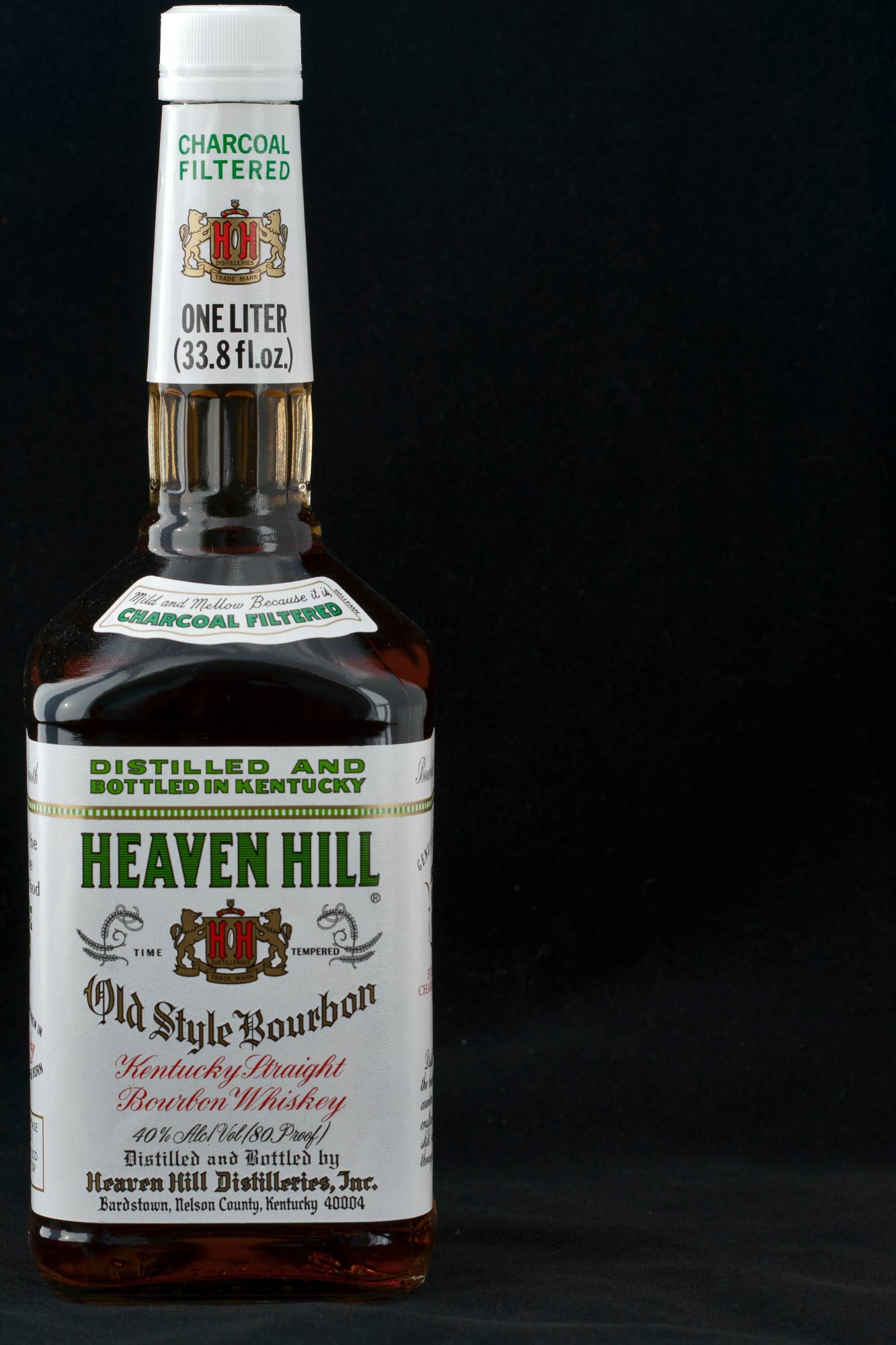 A bottle of heaven hill whiskey on a black background