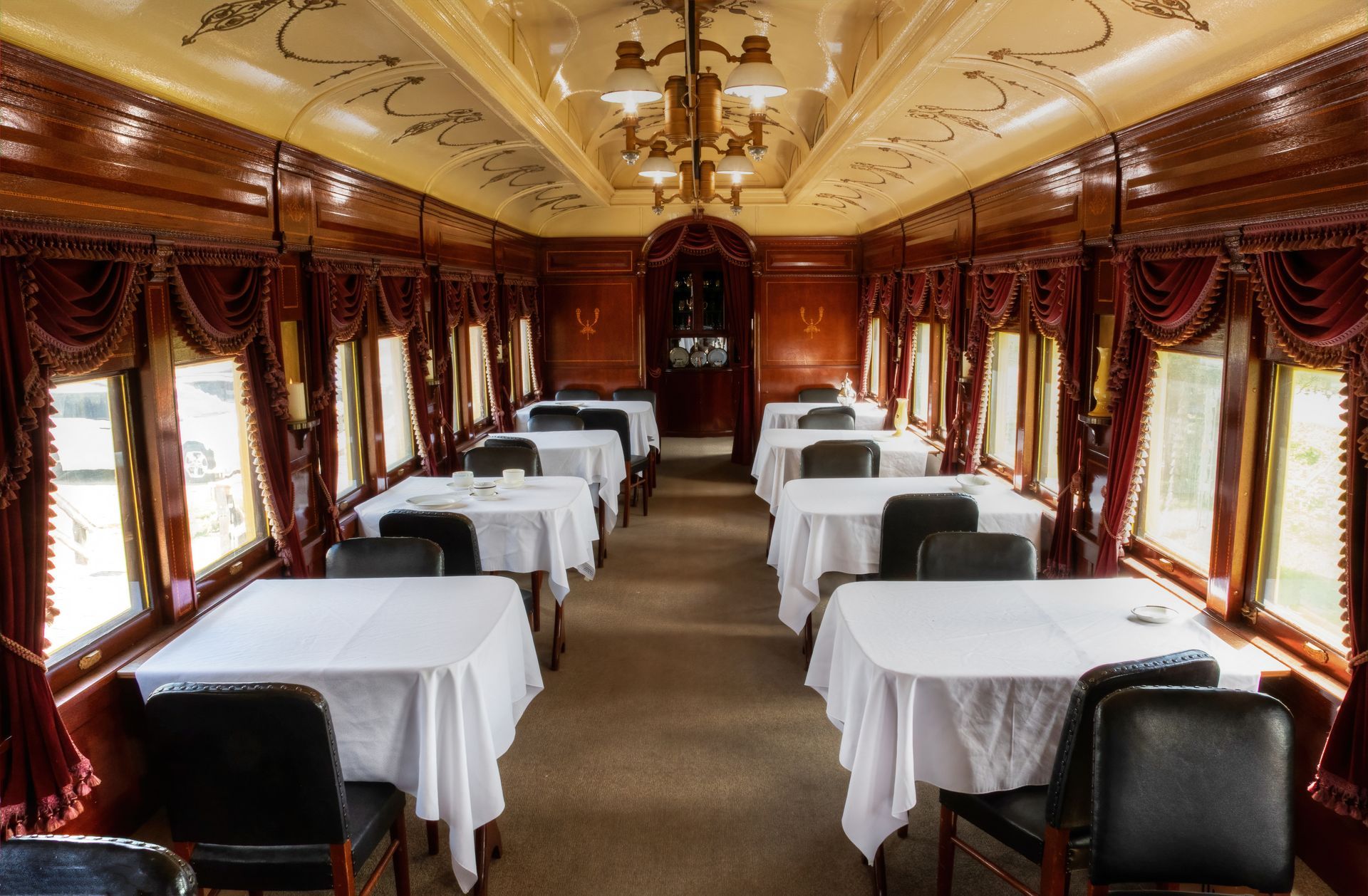 The inside of a train car with tables and chairs.