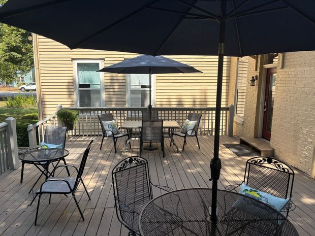 A dining room table with plates , napkins , silverware and a vase of flowers.