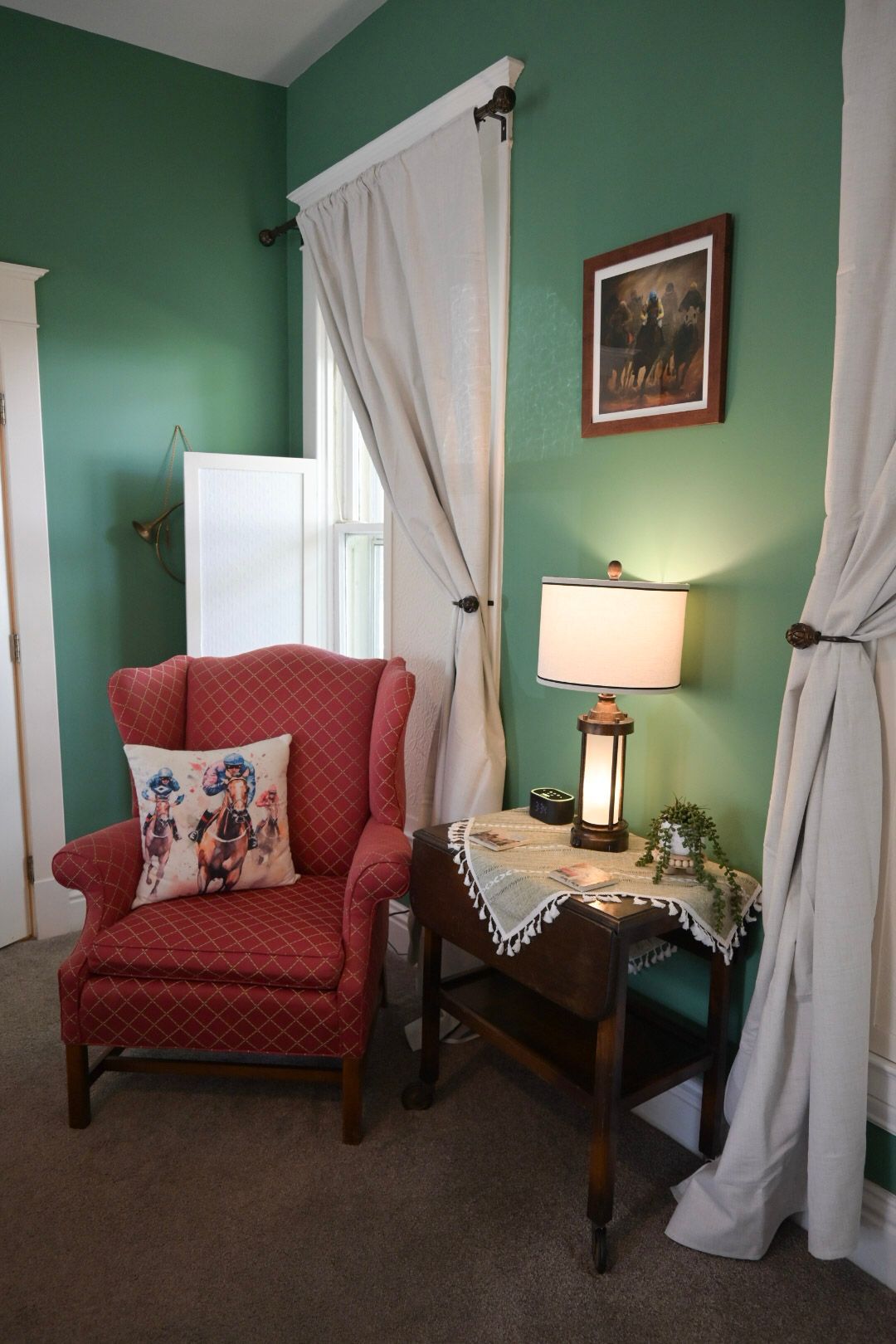 A bedroom with a four poster bed , chairs and a fireplace.