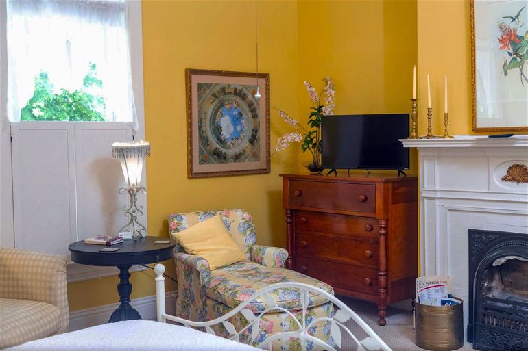 A living room with yellow walls and a fireplace