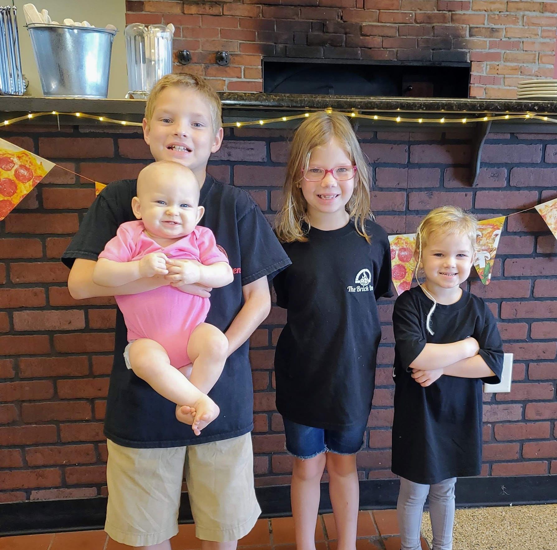 Boy Holding Bakers Paddle Pizza — Delicious Italian Pizza in Foley, AL Boy Holding Bakers Paddle Pizza — Delicious Italian Pizza in Foley, AL