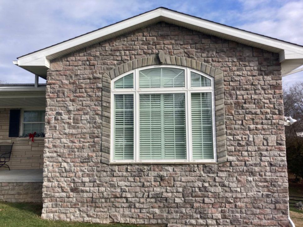 A brick house with a large window on the side of it.