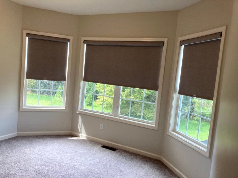 A room with a lot of windows and blinds on them.