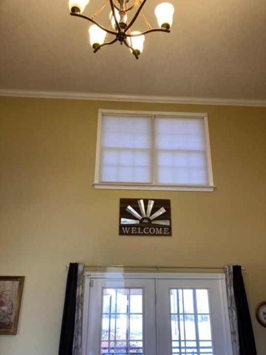 A welcome sign hangs above a window in a living room