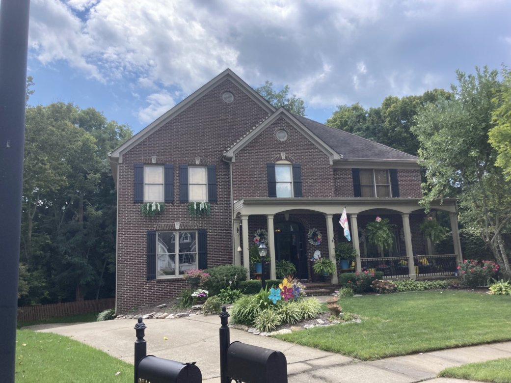A large brick house with a mailbox in front of it.