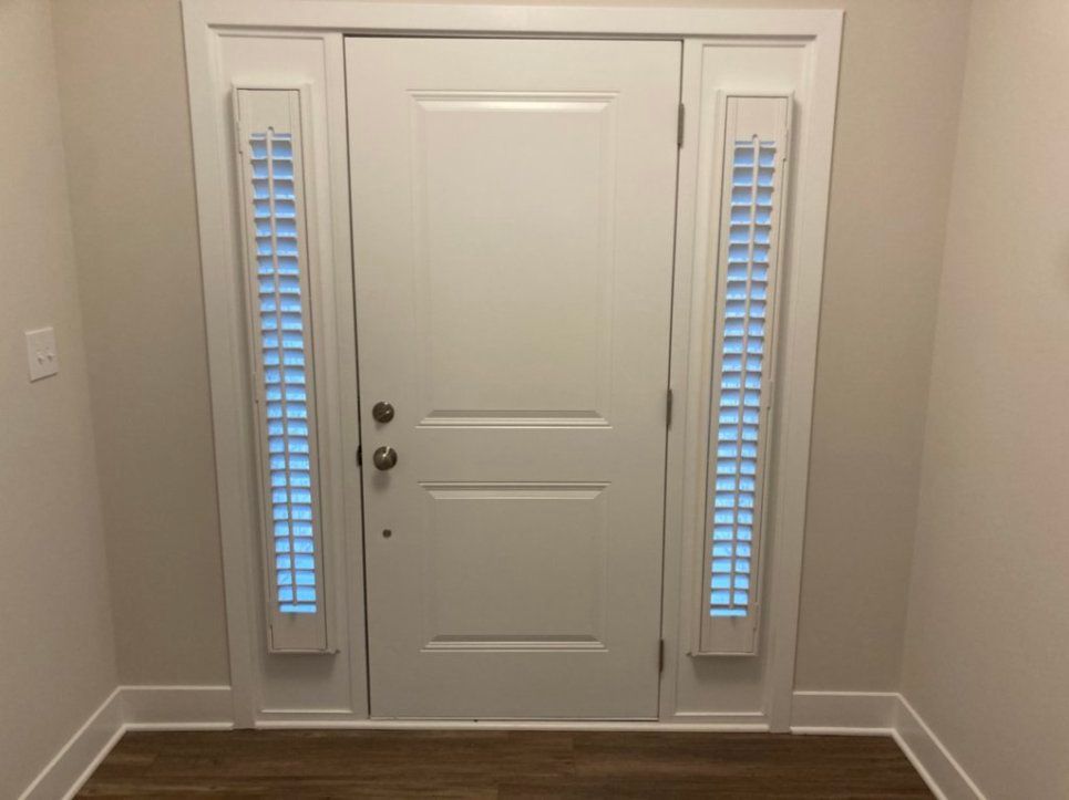 A white door with blue shutters in a hallway.