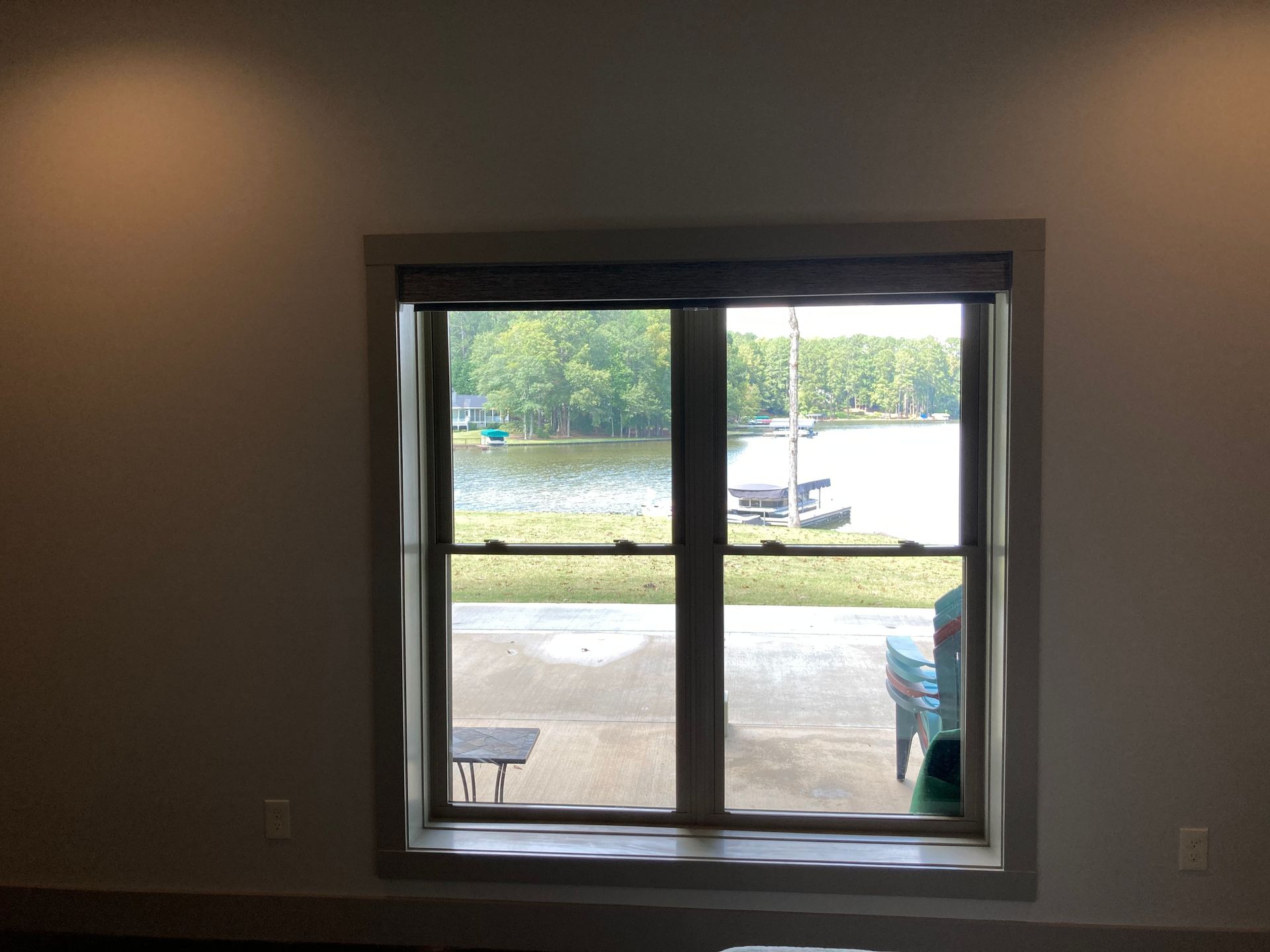 A window in a room with a view of a lake.