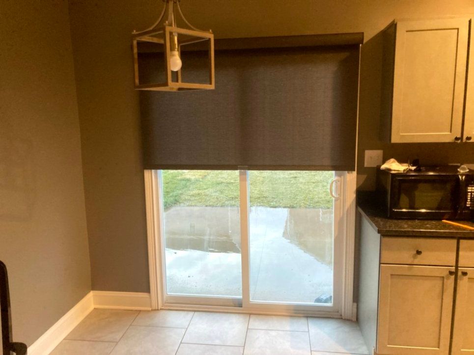 A kitchen with a sliding glass door and a microwave.