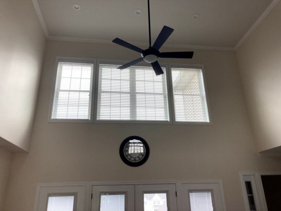 A ceiling fan is hanging from the ceiling above a window