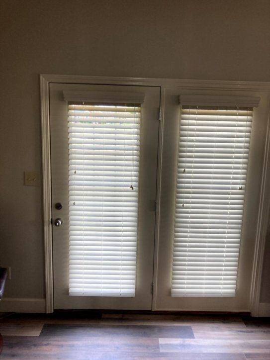 A room with a door and blinds on it.
