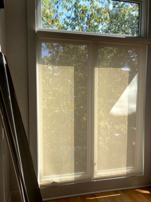 A large window with blinds on it in a living room.