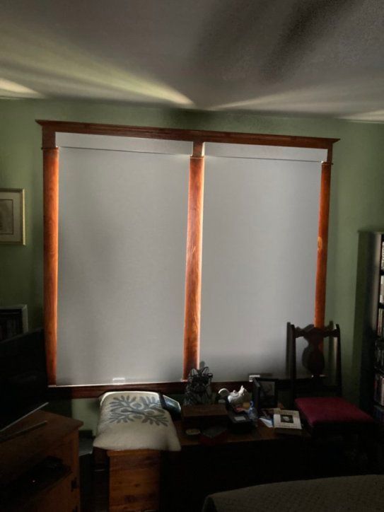 A living room with white blinds on the windows