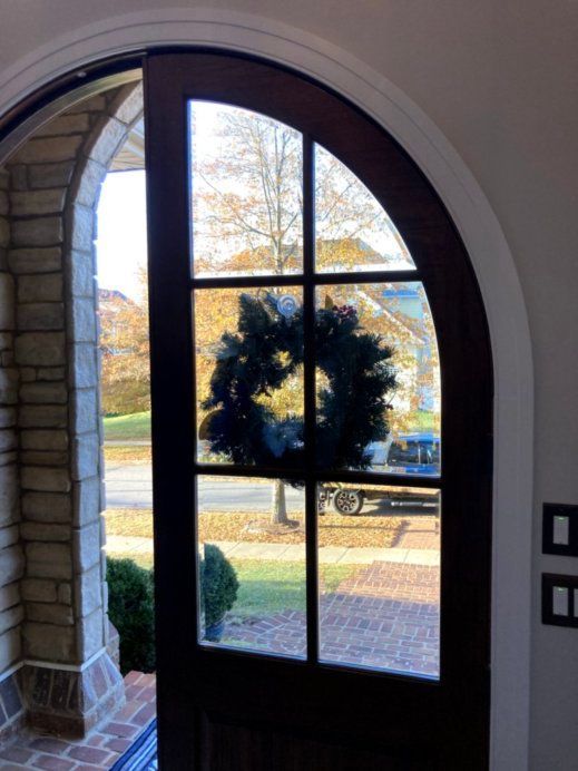 A door with a wreath on it and a car in the background