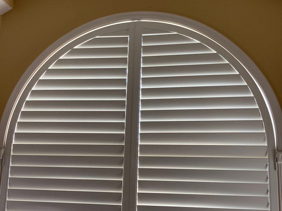 A close up of a window with arched shutters
