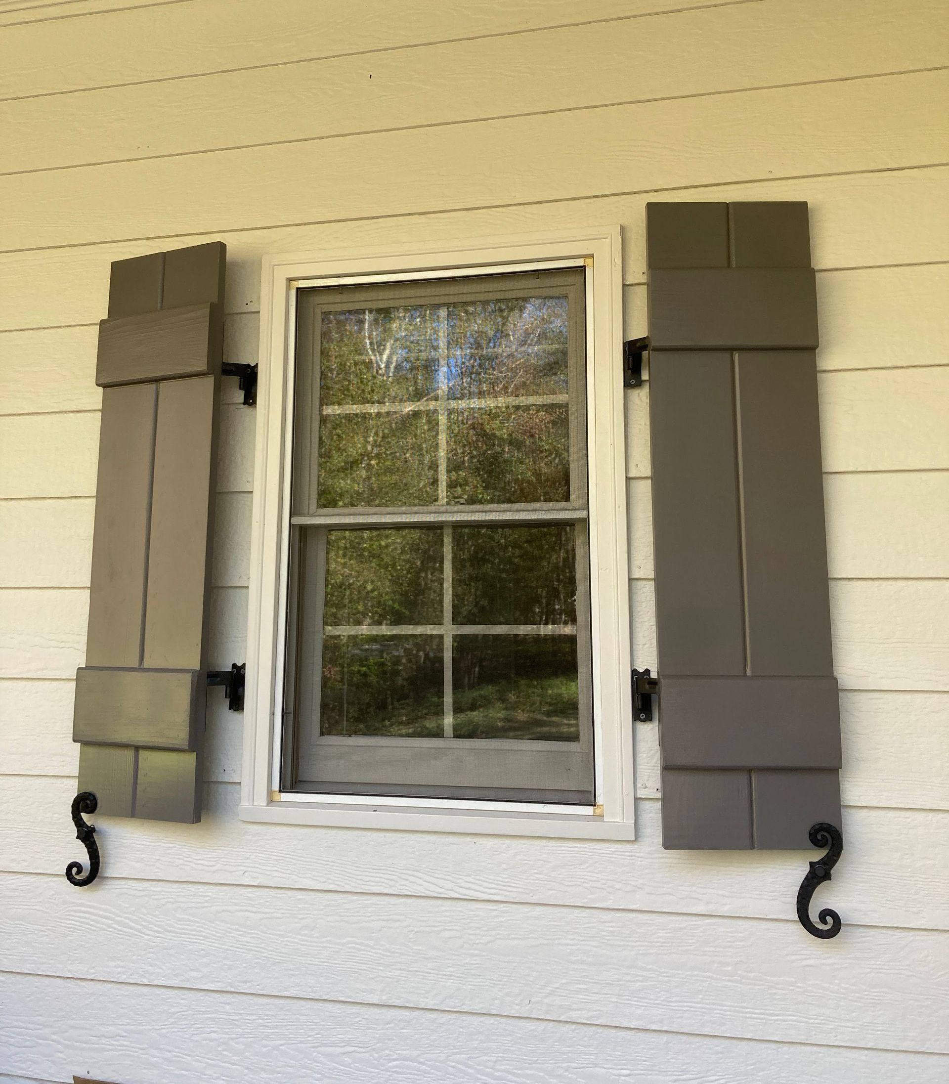 A window with shutters on the side of it