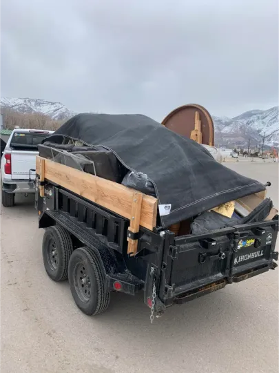 A dump truck is pulling a trailer full of trash.