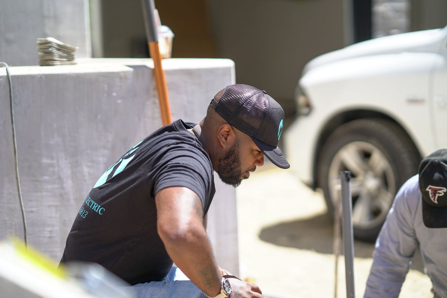 A man wearing a hat with the letter t on it