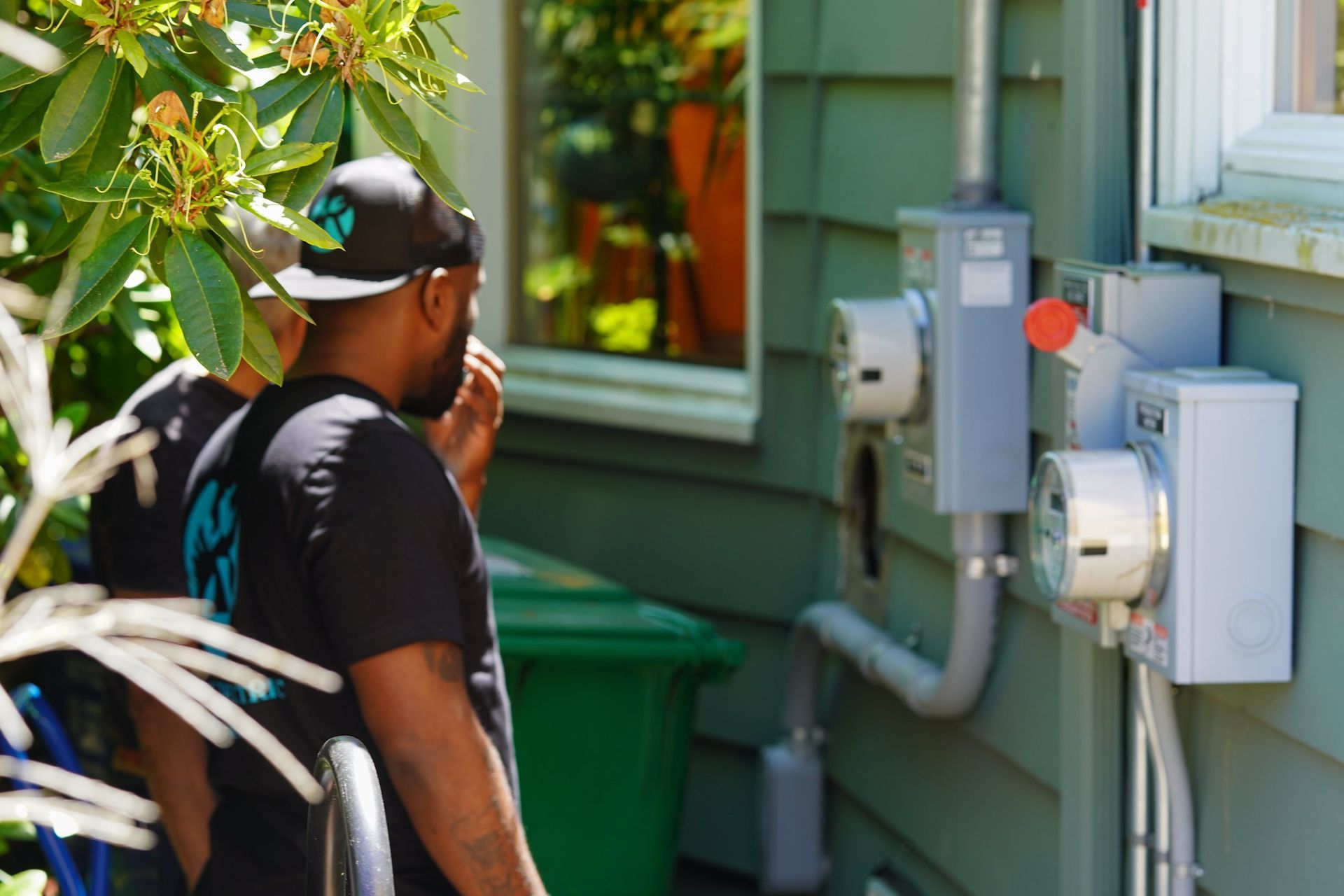 A man standing in front of a house talking on a cell phone