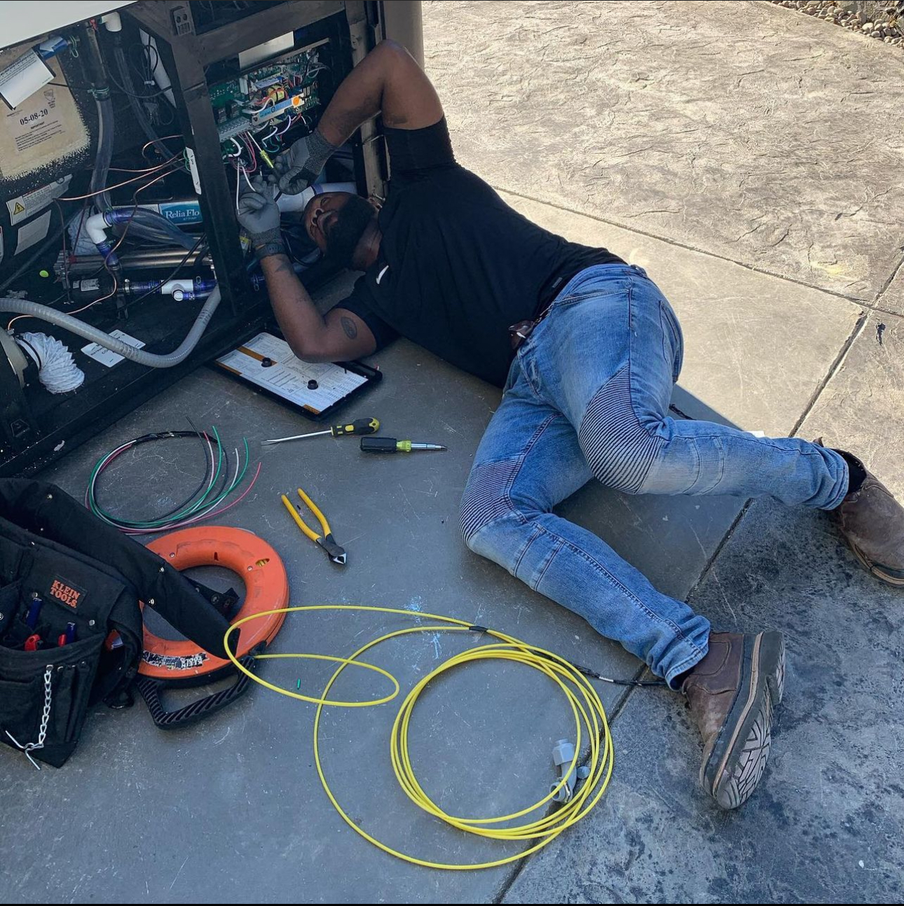 A man laying on the ground working on a computer