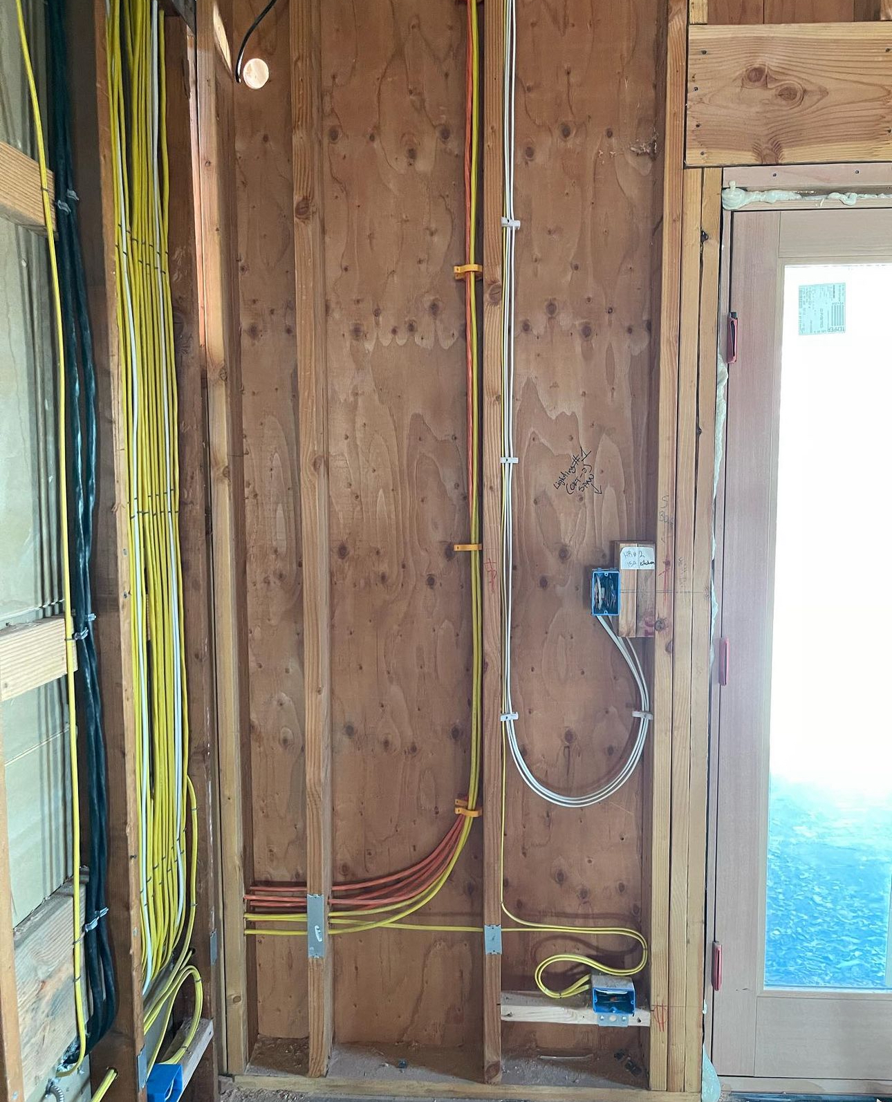 A wooden wall with electrical wires coming out of it