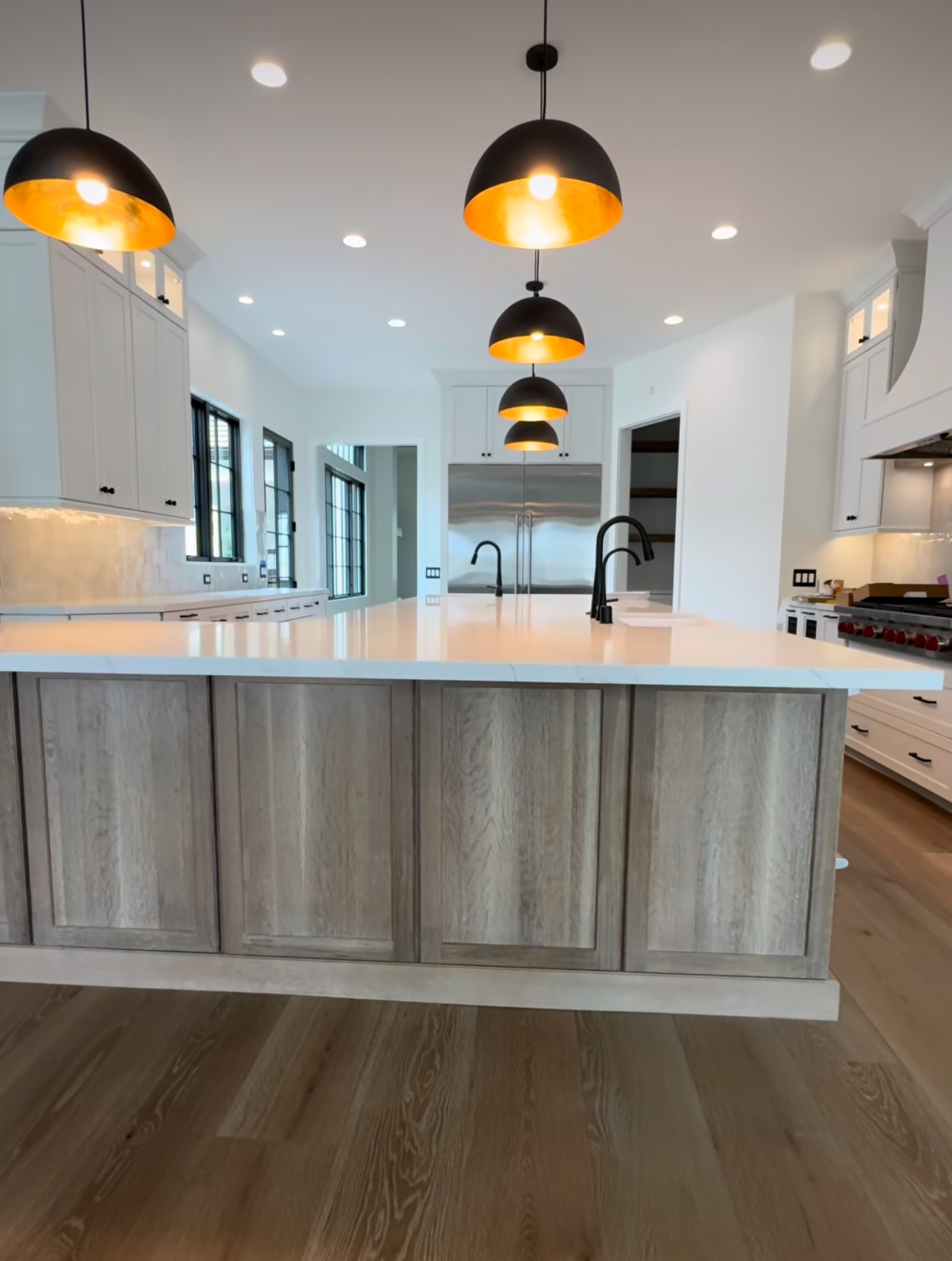 A kitchen with white cabinets and a large island