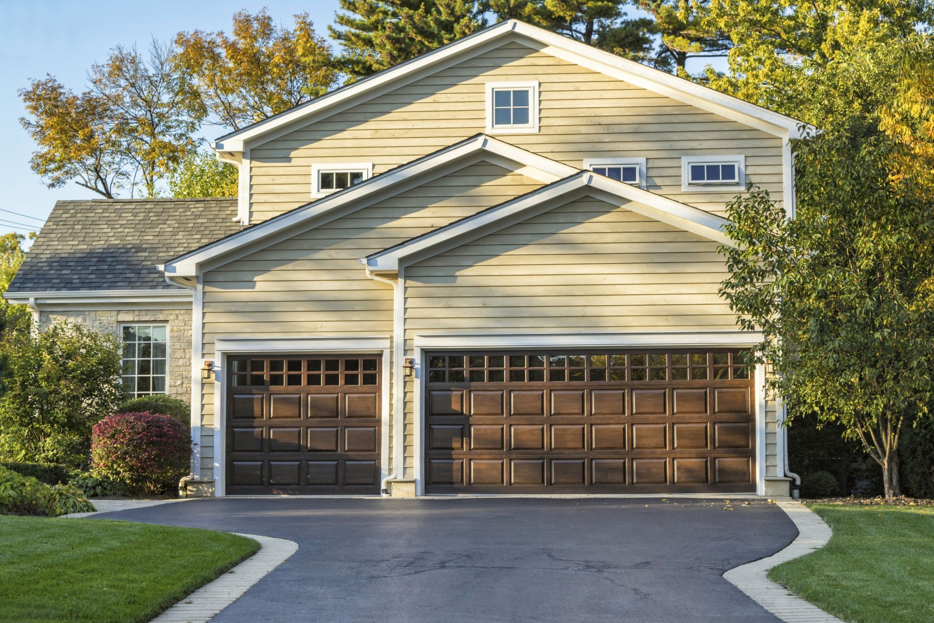 A large house with two garage doors and a driveway