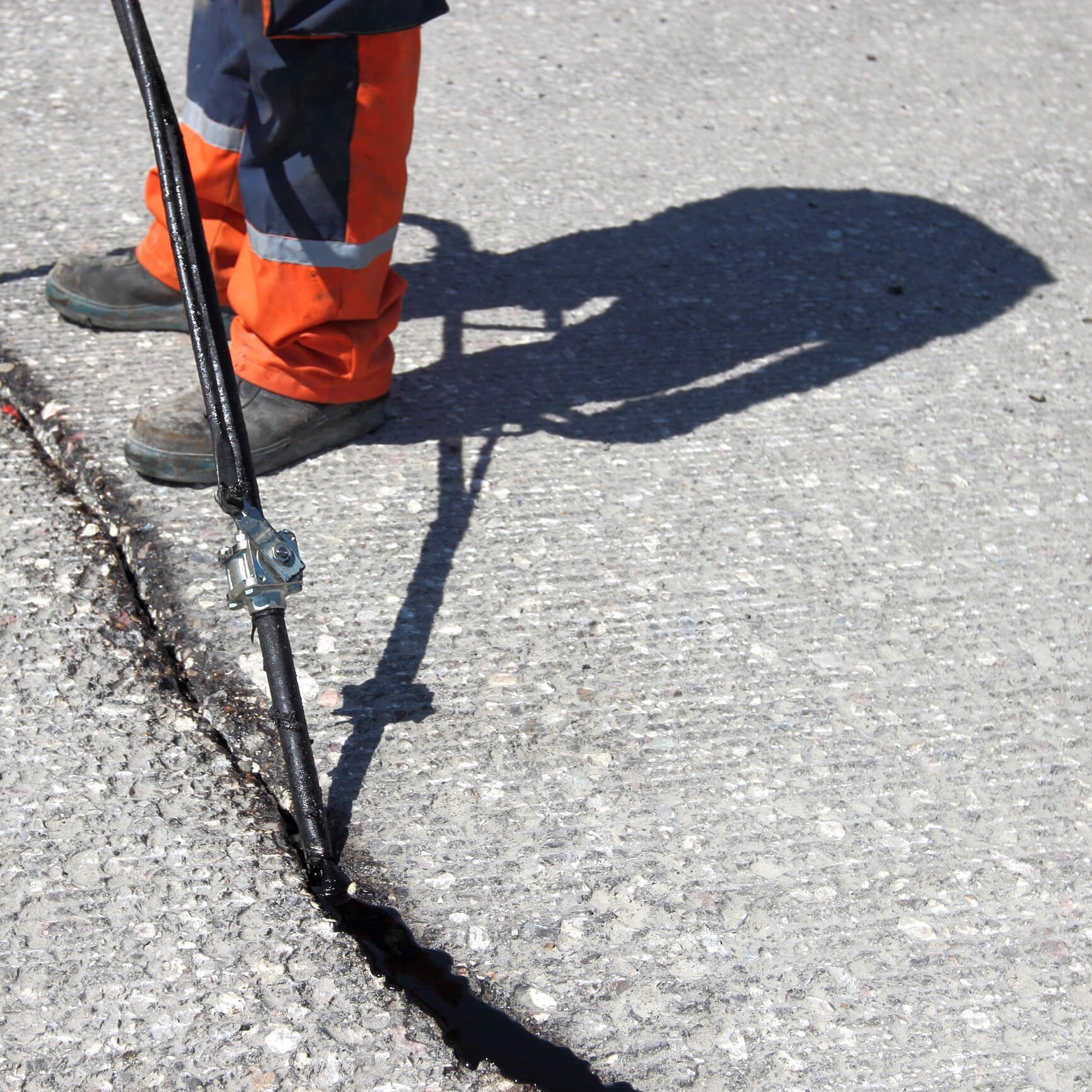A person in orange pants is standing on a concrete surface
