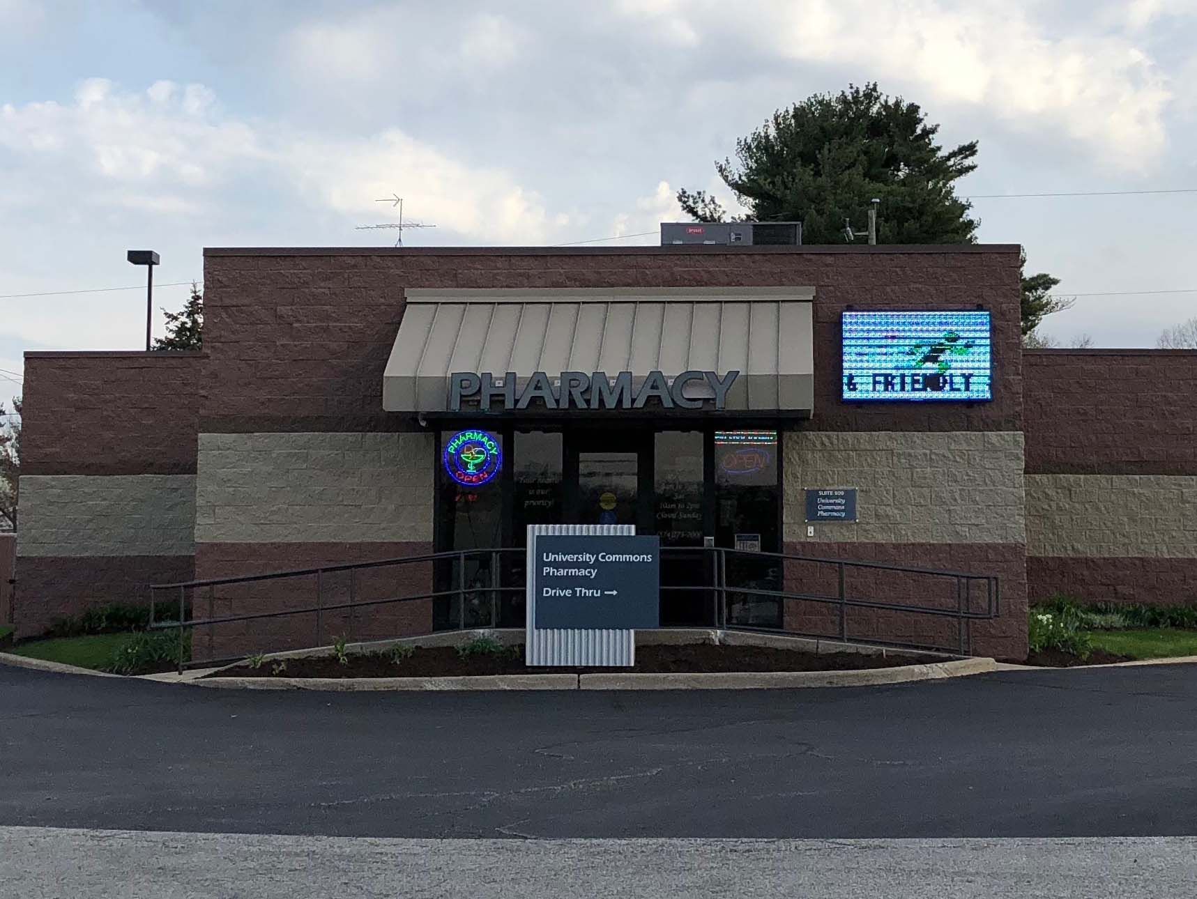 Brick storefront with a sign above the entrance and a lit menu board on the right.