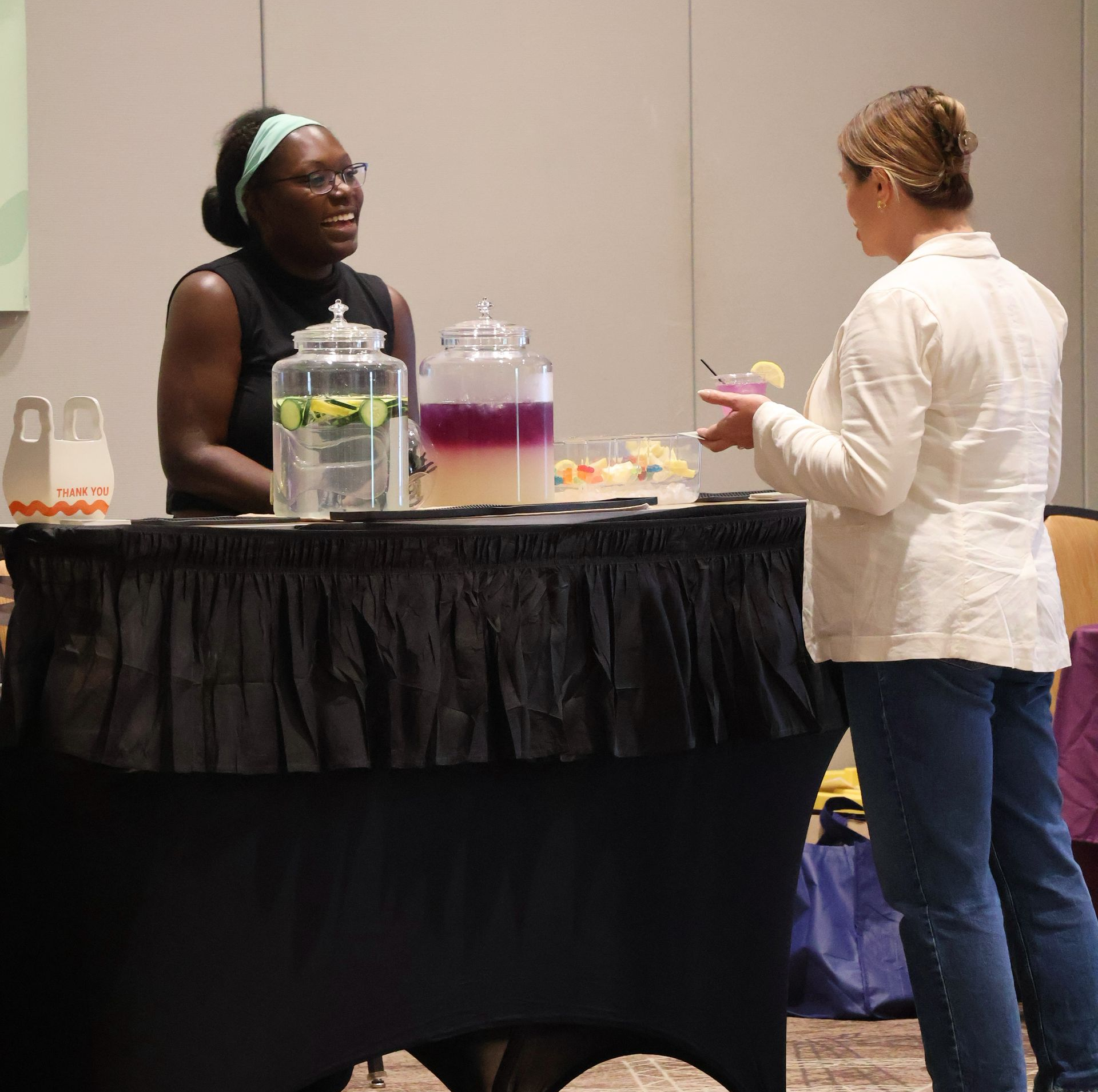 A bottle of wine and wine glasses are on a table.