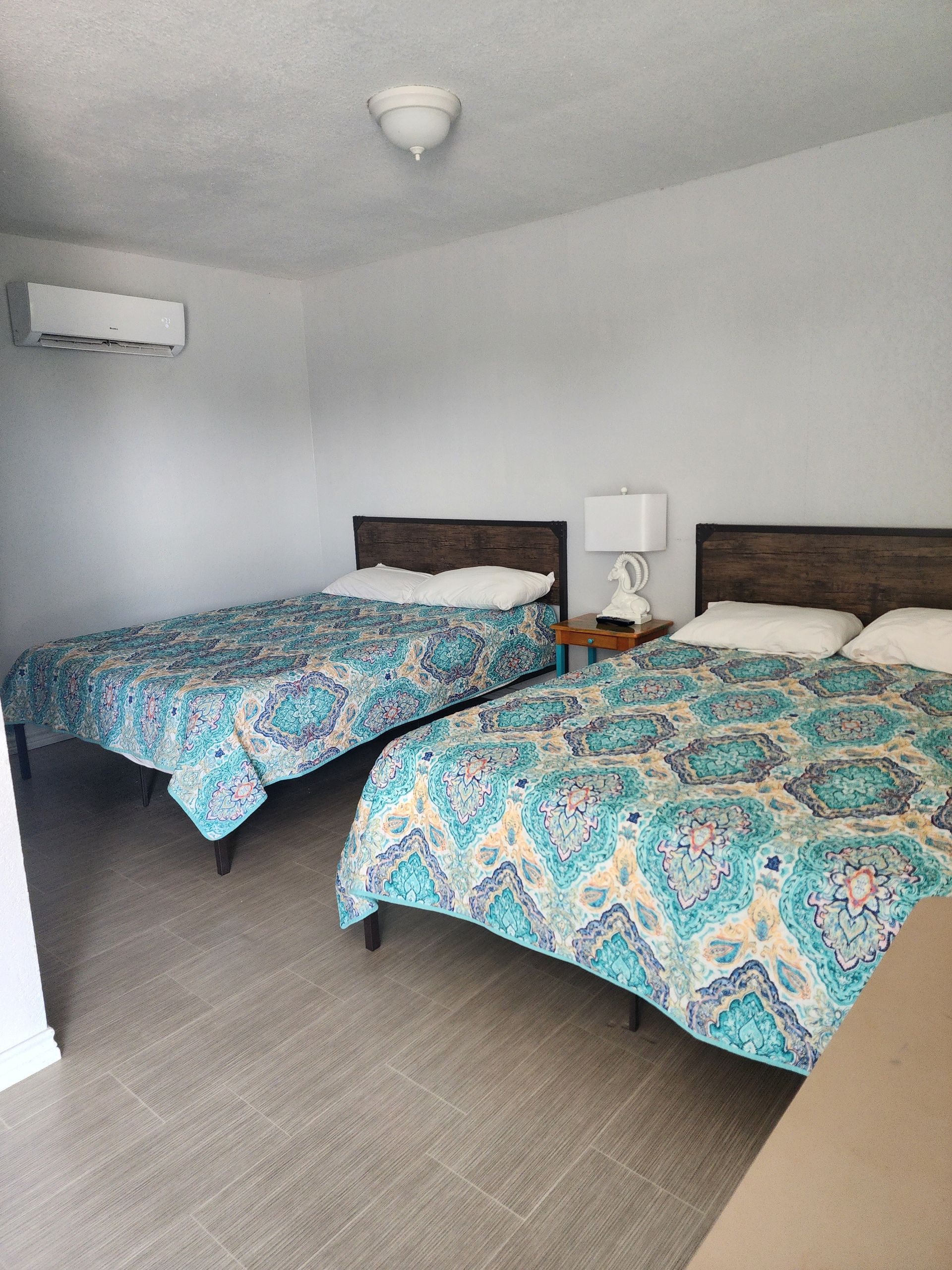 A bedroom with two beds and a picture on the wall