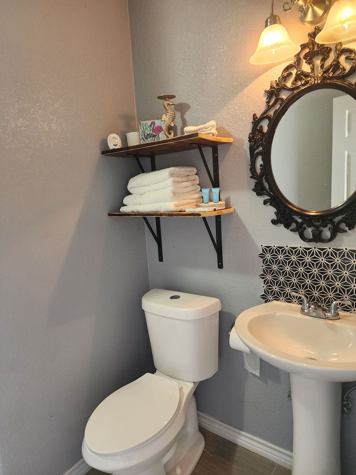 A bathroom with a toilet , sink and mirror.