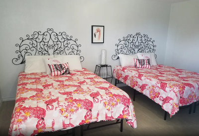 A bedroom with two beds and a picture on the wall