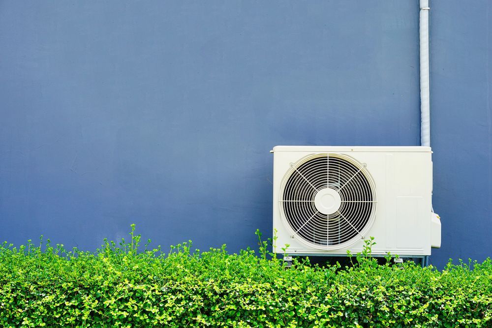 A Close Up of a White Air Conditioner Hanging on a Wall — Air-Con Cleaning Specialists in Redlynch, QLD