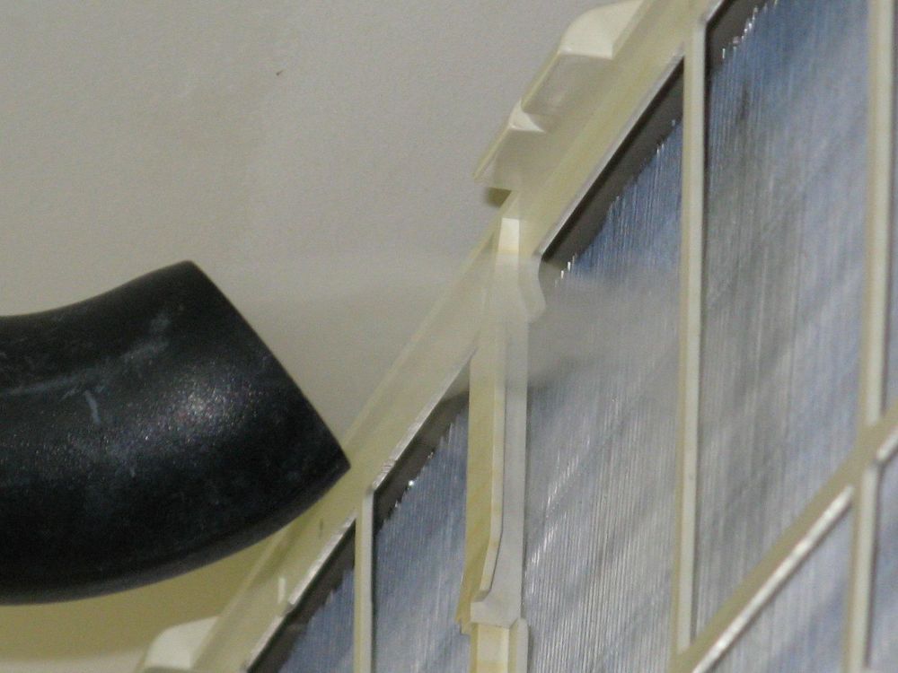 A Black Pipe is Attached to the Side of a Building — Air-Con Cleaning Specialists in Trinity Beach, QLD