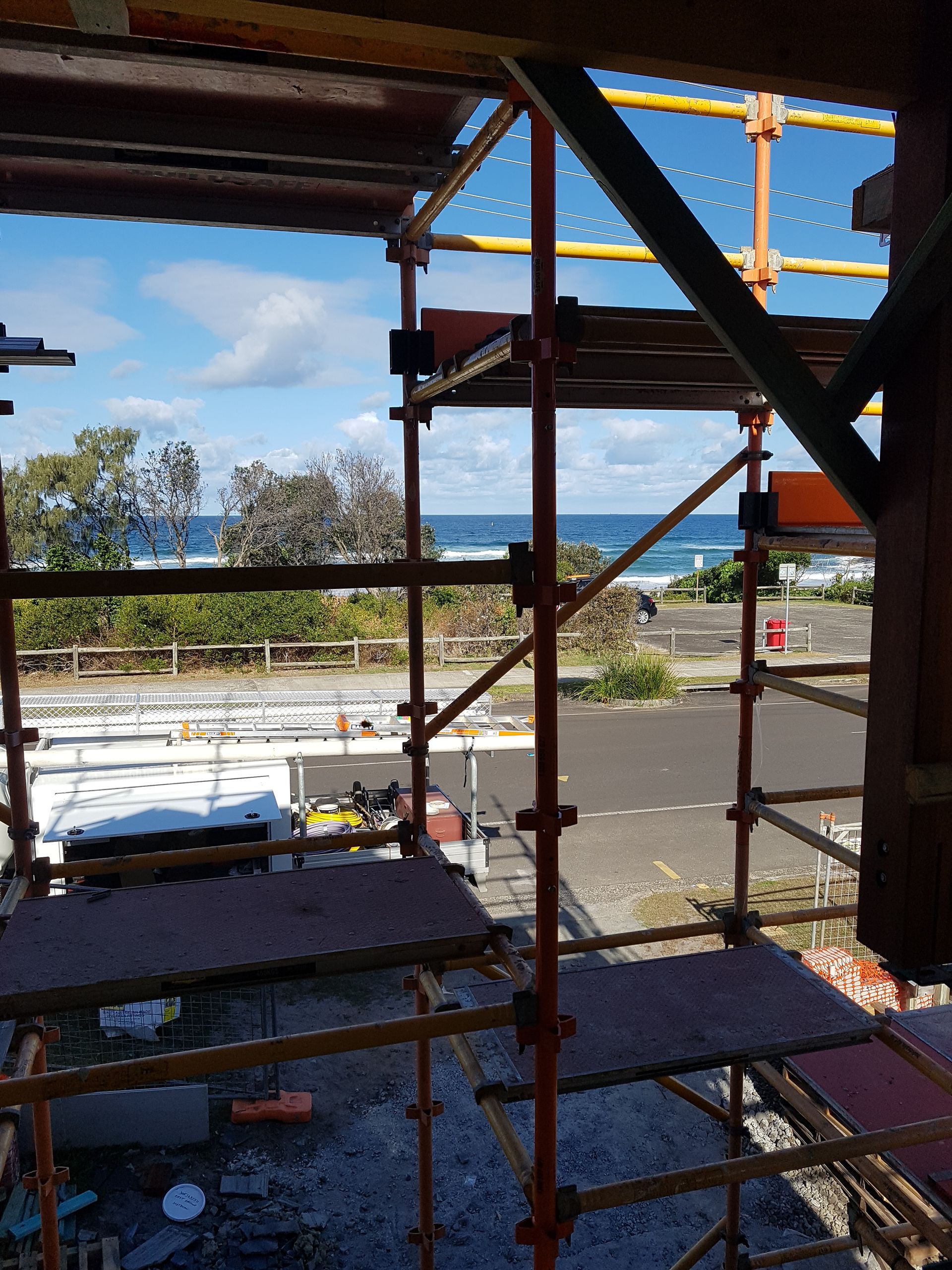 A Construction Site With Scaffolding and a View of the Ocean — Bevan Plumbing in South Lismore, NSW