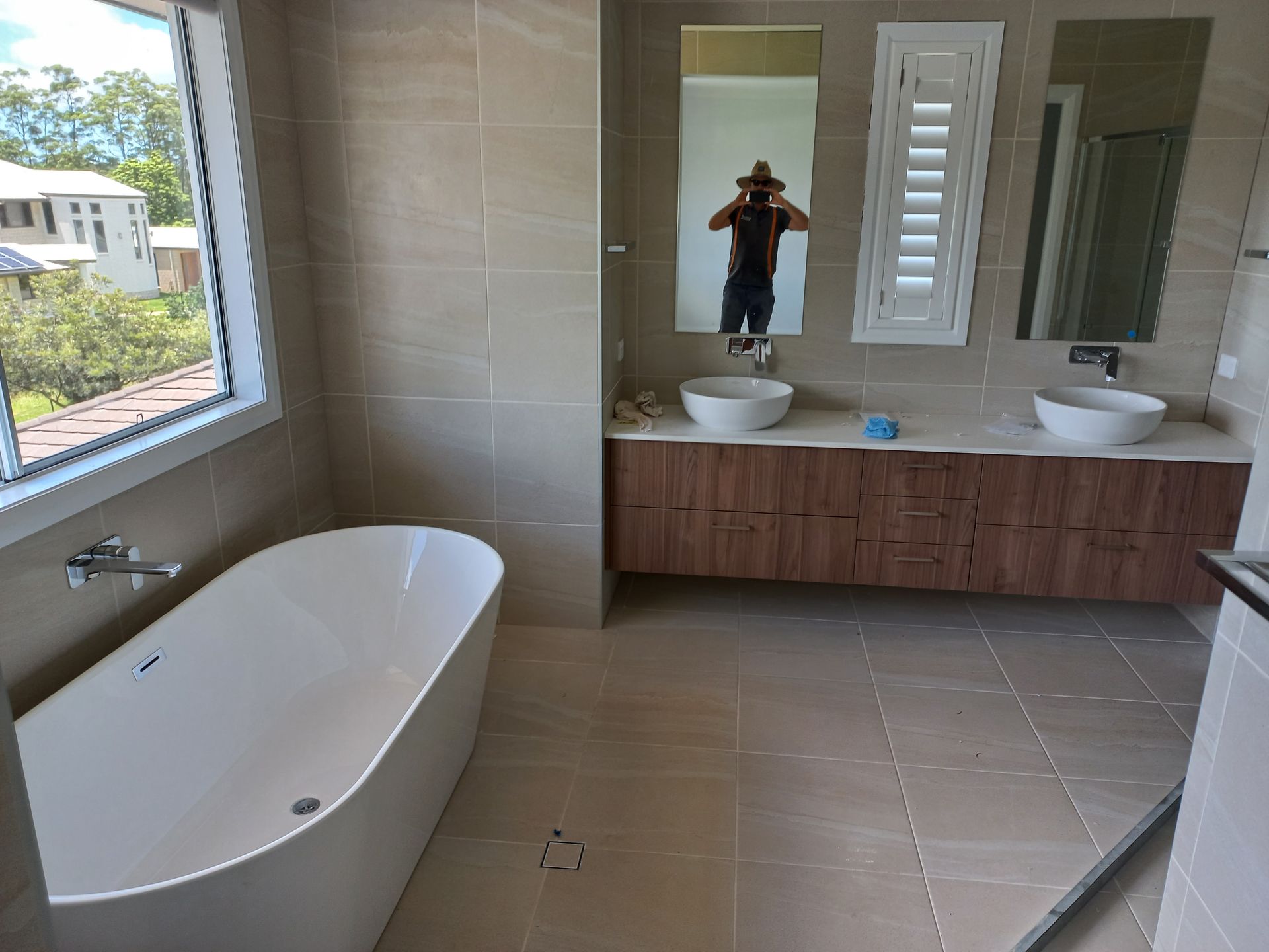 A Bathroom With a Bathtub , Sinks , Mirrors and a Window — Bevan Plumbing in South Lismore, NSW