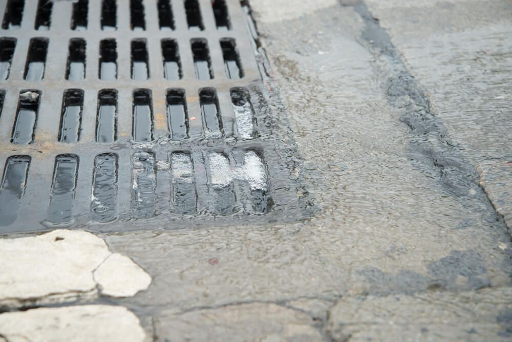A Close Up of a Manhole Cover on a Sidewalk — Bevan Plumbing in Evans Head, NSW