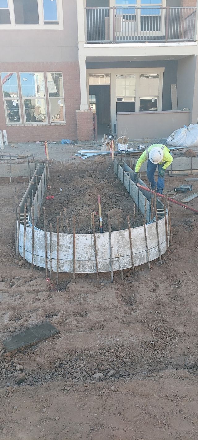 A construction worker near a U-shaped concrete form on a construction site.