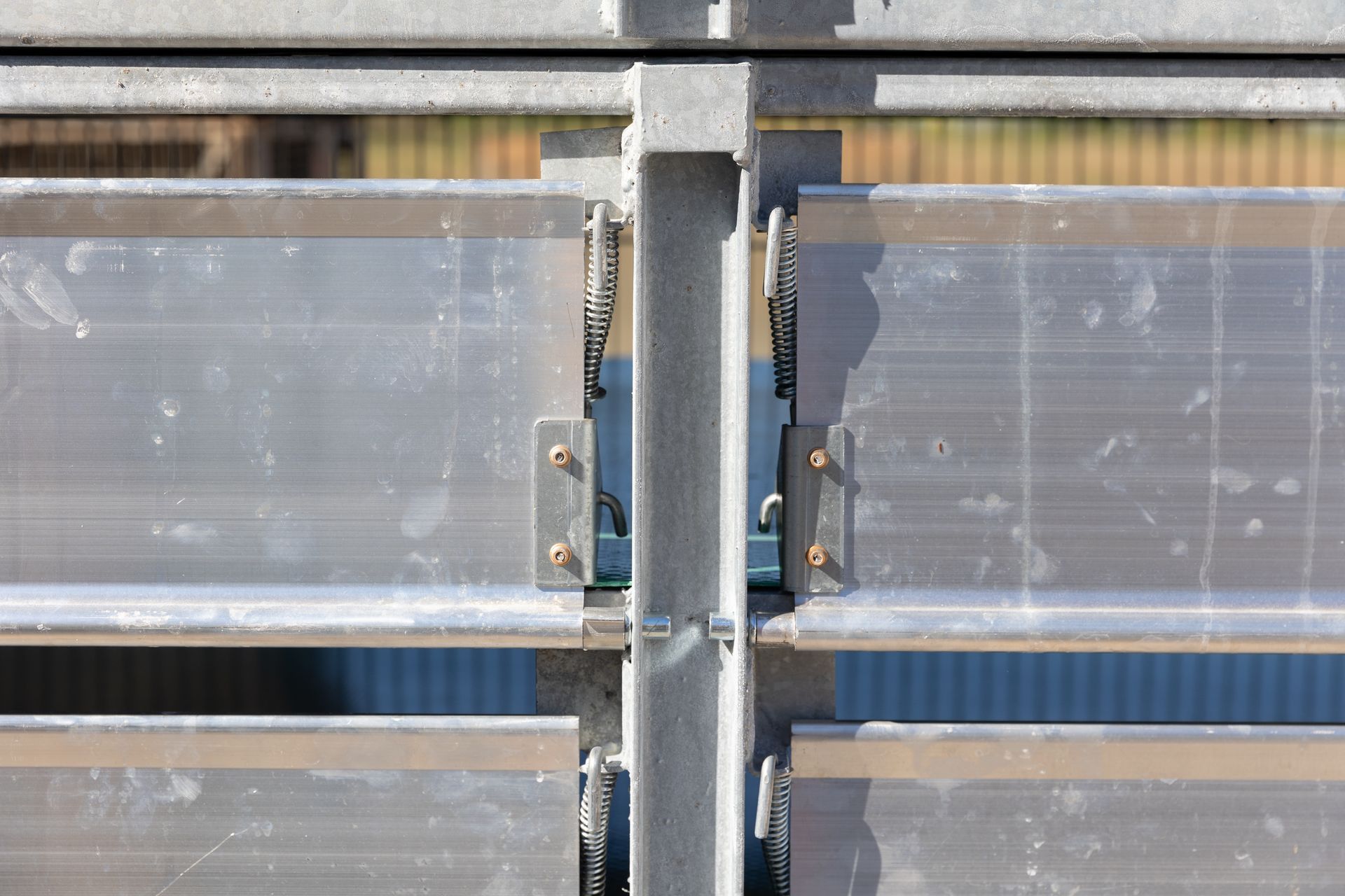 Horizontal metal slats, likely a fence or wall, joined by vertical support beams.