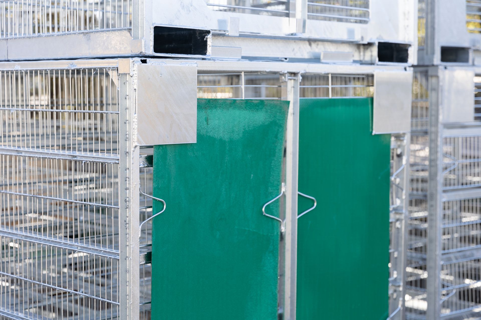 Metal storage containers stacked with green plastic panels.