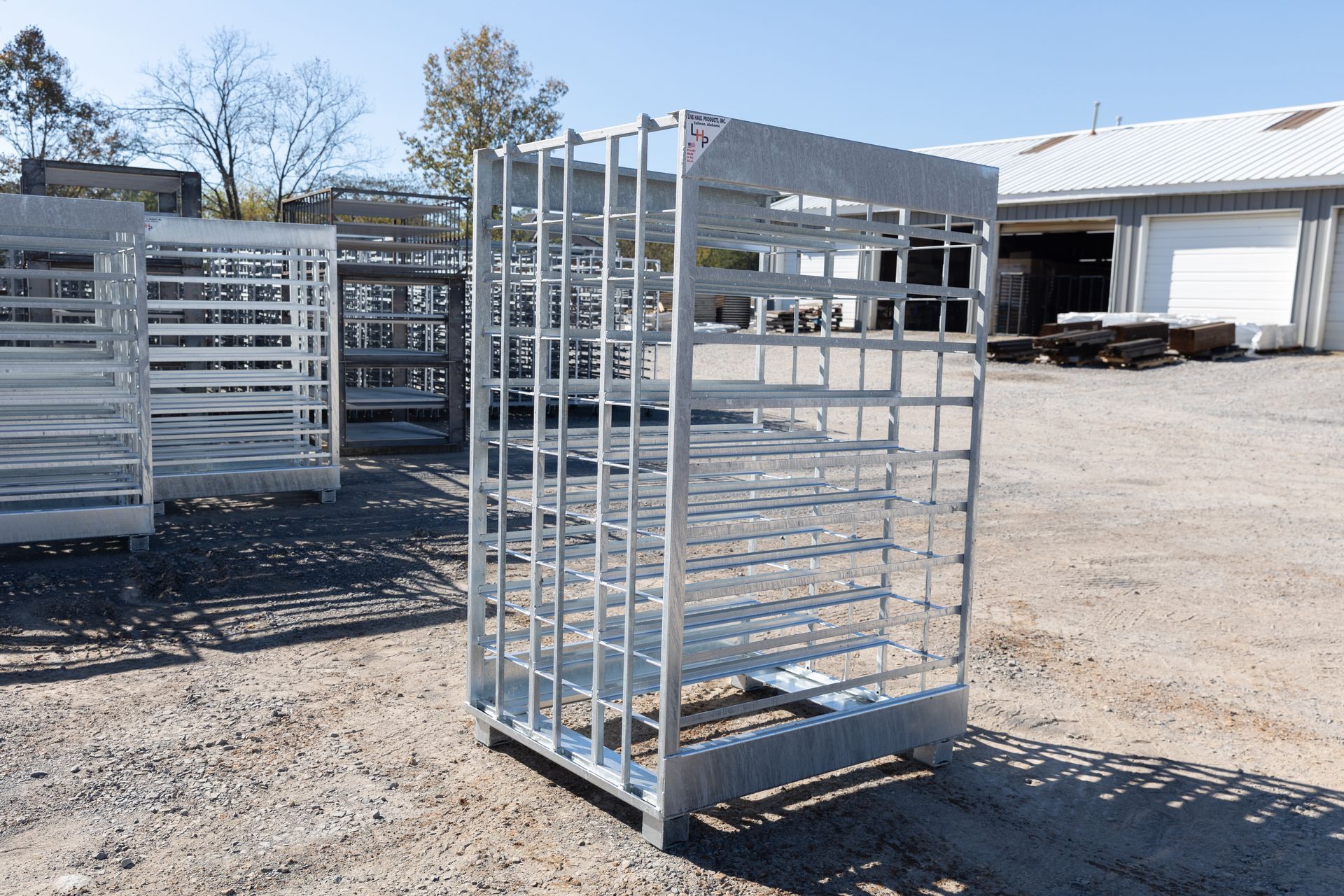 Metal storage cages outdoors, in front of a building on a sunny day.