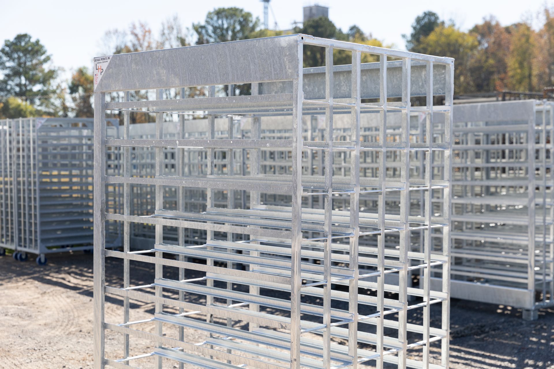 Metal storage cages outdoors, in front of a building on a sunny day.