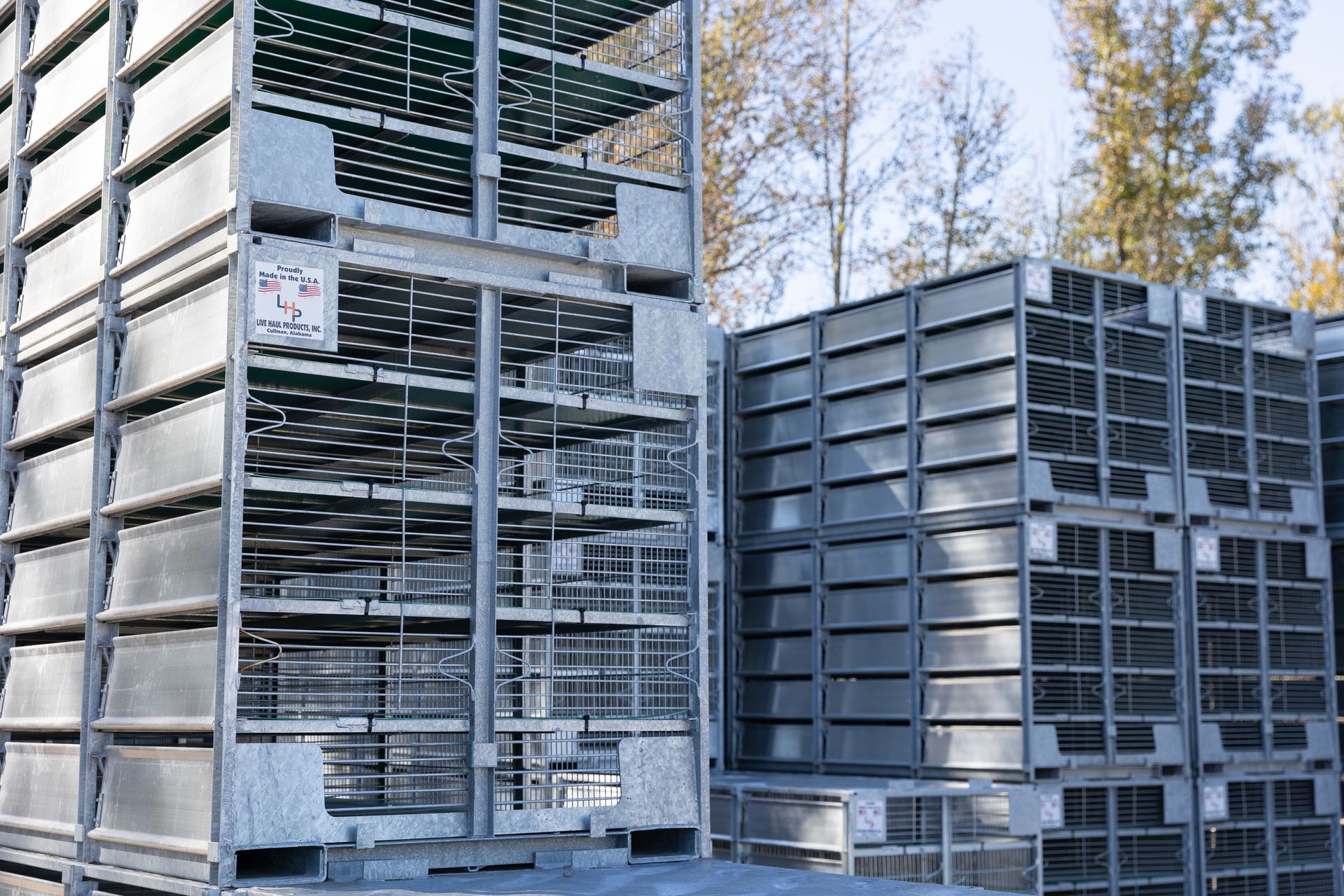Metal poultry crates stacked outdoors.